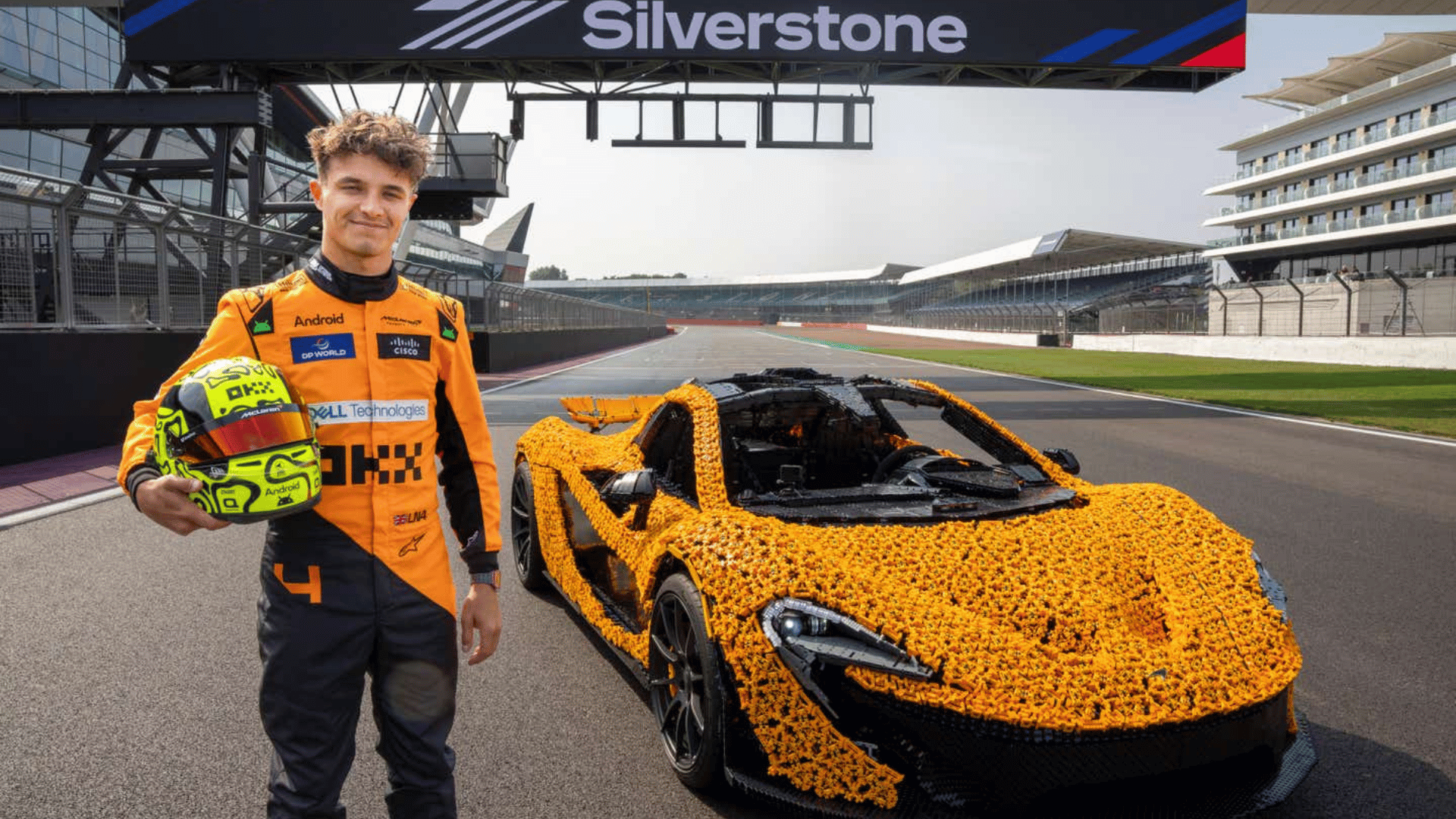 Lando Norris standing next to LEGO and McLaren Automotive P1