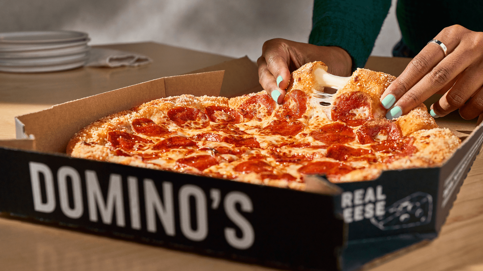 Hand's pulling apart stuffed crust pizza.